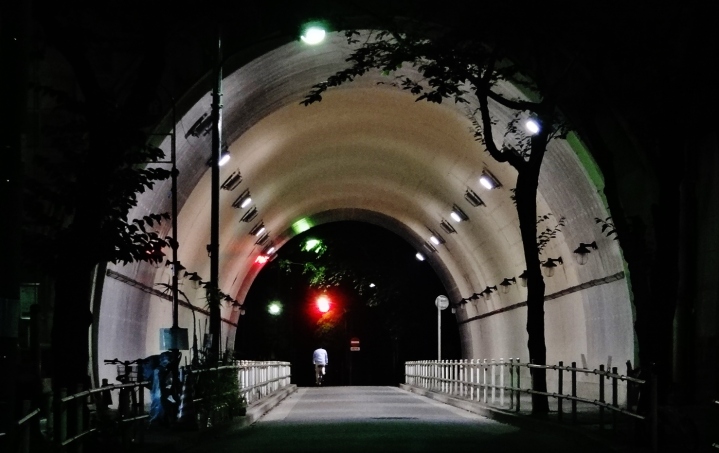 Man biking through Atago tunnel at night, Kamiyacho Tokyo.